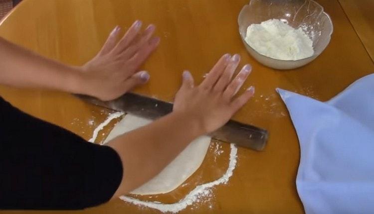We roll out each ball of dough with a rolling pin.