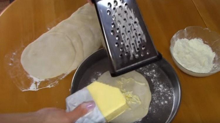 Por cada ronda de masa frotamos mantequilla fría.