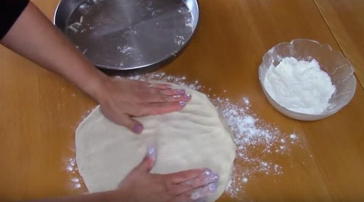 The resulting cake is compacted with hands on the working surface.