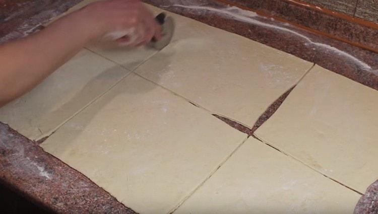 We cut the dough into equal squares.