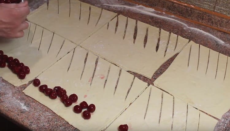 Mettez les cerises sur un morceau de pâte sans entailles.