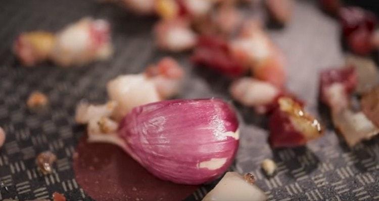 Add crushed garlic clove to the bacon.