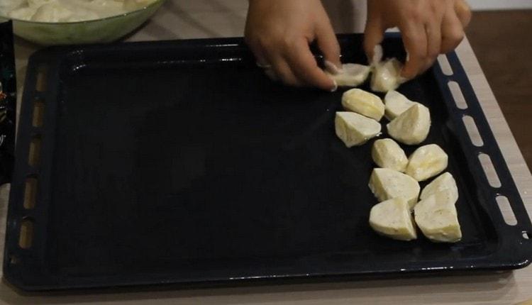 Extendemos las papas en una bandeja para hornear engrasada con aceite vegetal.