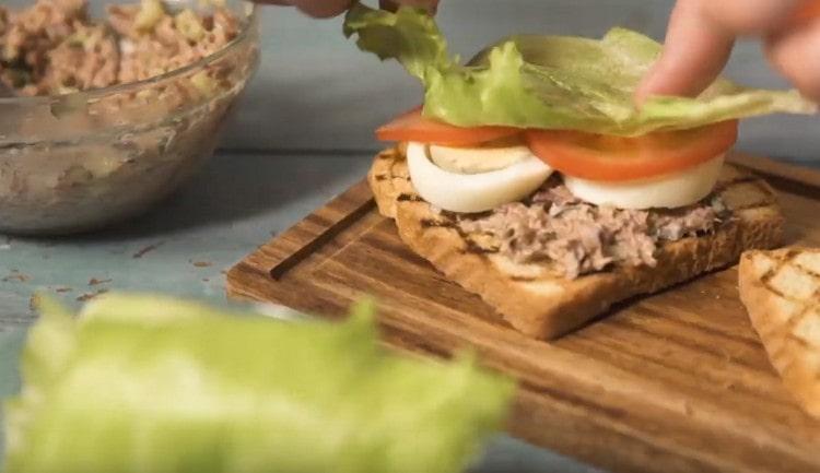 Sur le thon, on étale les tranches d'œuf, les tranches de tomate et une feuille de laitue.