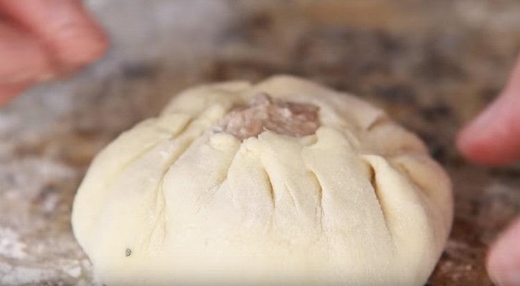 Having laid the filling on the tortilla, we collect the dough around it with a bag.