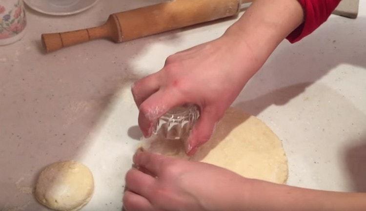 Découpez des morceaux de pâte ronds avec un verre.