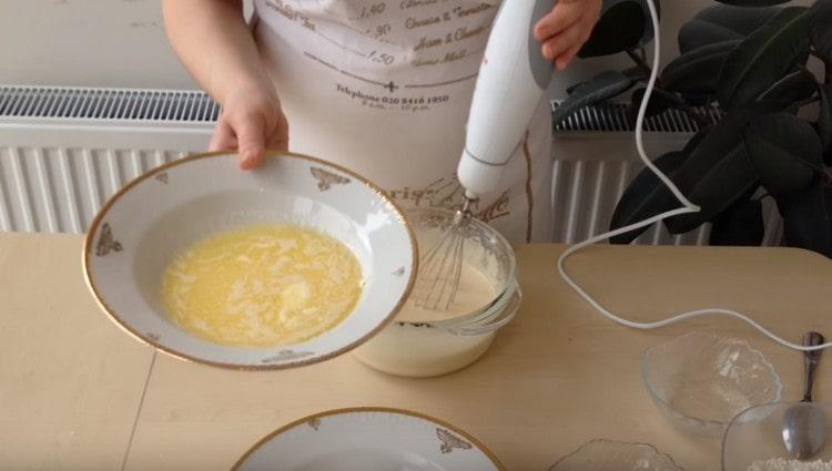 En fouettant continuellement, ajoutez le beurre fondu à la masse d’œufs.