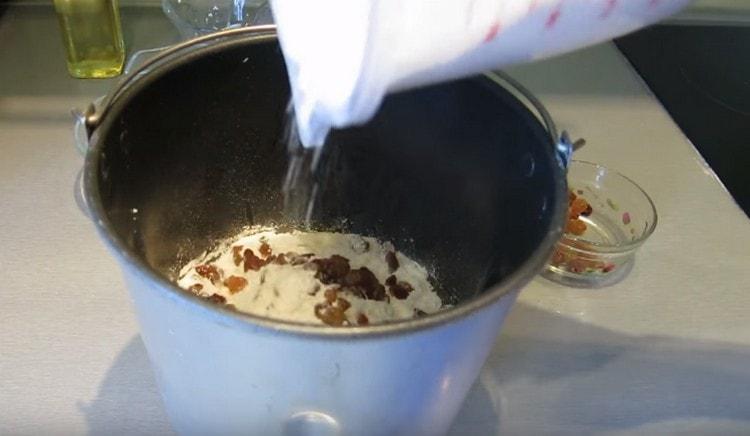 Naizmjence dodajte grožđice i brašno u tijesto.