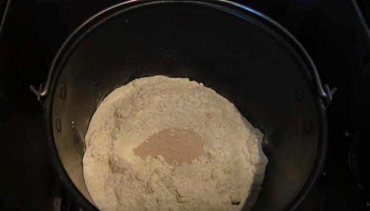 A bucket filled with ingredients, set in a bread machine.