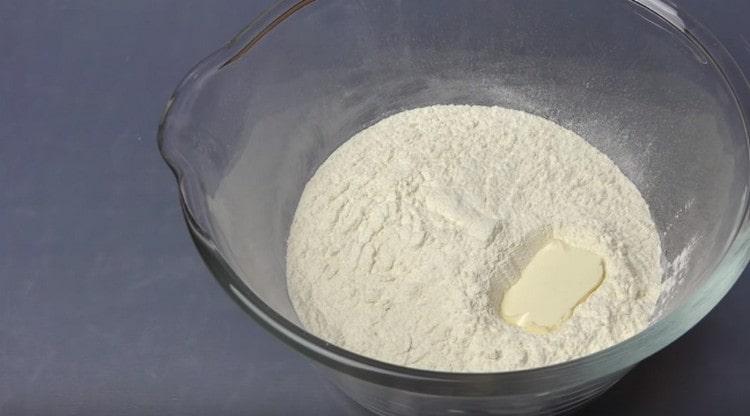 Agregue la mantequilla ablandada a la harina.