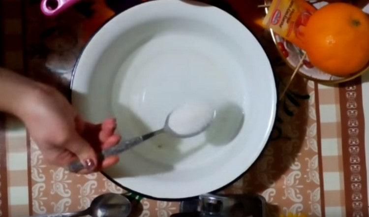 Pour warm water into a bowl and add sugar to it.