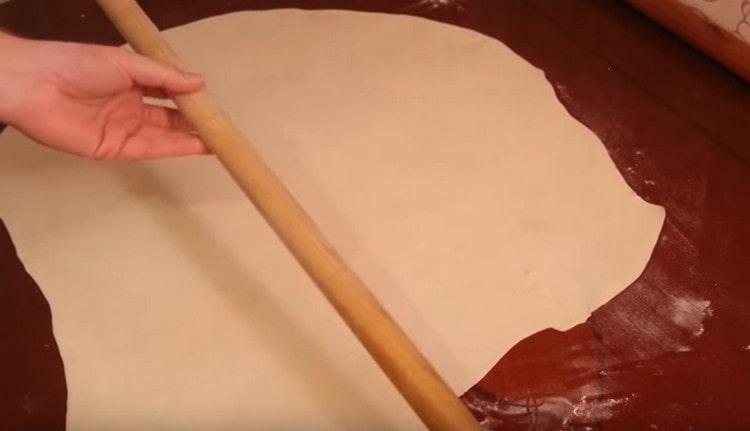 Roll out the dough as thin as possible with a rolling pin.