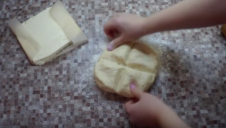 We take out the dough from the refrigerator and visually divide it into 4 parts.