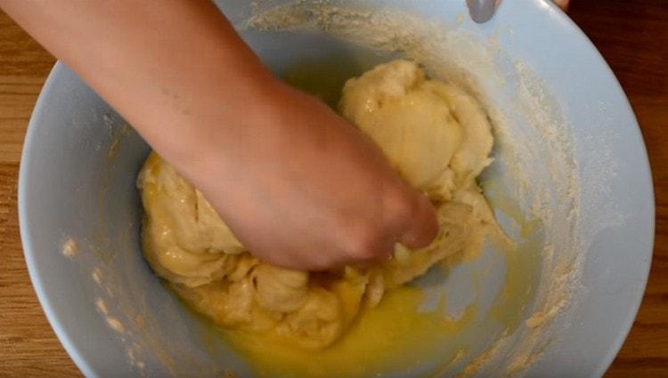 Umiješajte maslac u tijesto, dodajte još brašna.