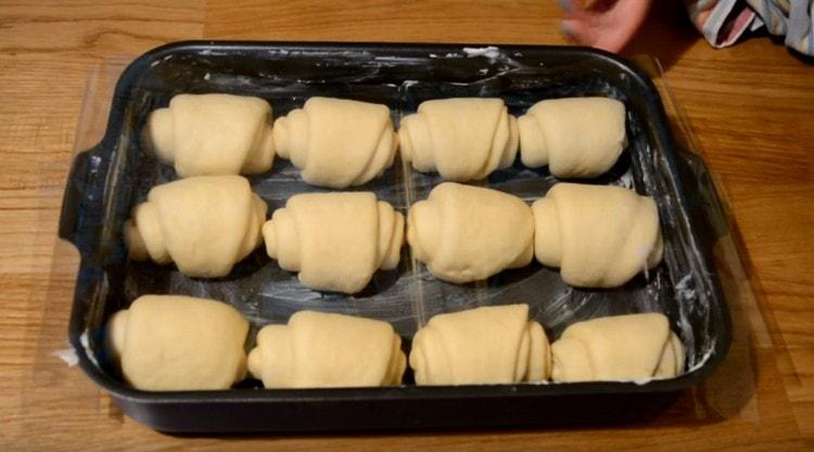 Nous étalons les petits pains obtenus sur une plaque à pâtisserie graissée de beurre et les laissons reposer afin qu’ils se détachent un peu plus.