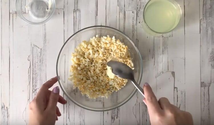 Add softened butter to the crushed eggs.