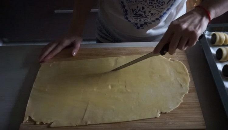 Abaisser la pâte finement et la couper en longues lanières.