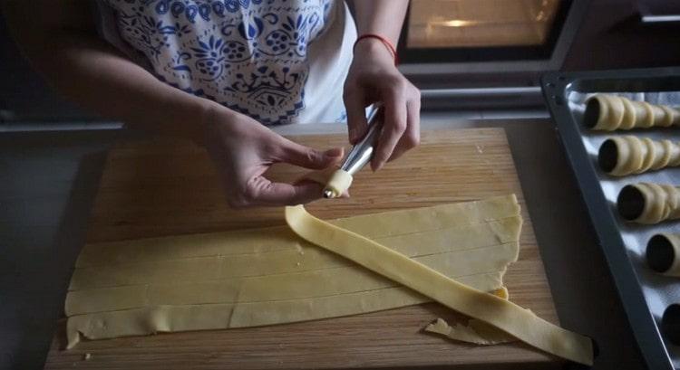We wrap each strip of dough on a tube shape.