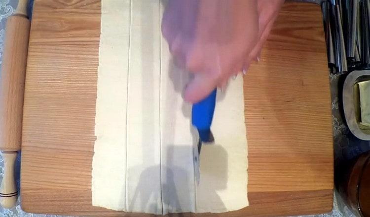Abaisser la pâte feuilletée en un rectangle et la couper en lanières.
