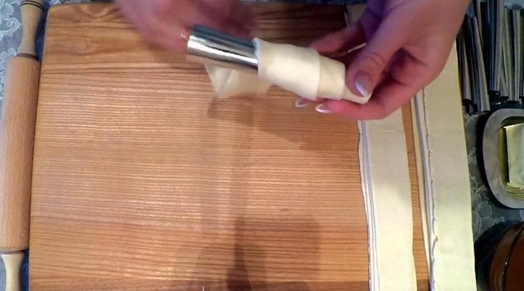 Enroulez des bandes de pâte autour de moules métalliques pour tubes.