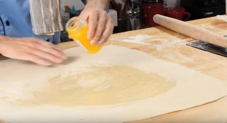 Lubrifiez la pâte roulée avec du beurre fondu.