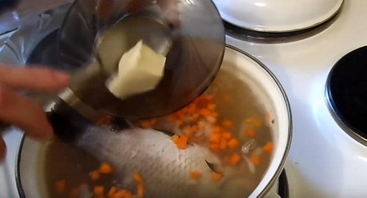 Après avoir ajouté du poisson à l'oreille, vous pouvez également y mettre un morceau de beurre, saler et poivrer au goût.