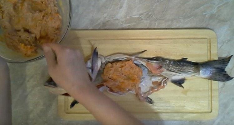 Después de colocar la piel del salmón rosado en el tablero, untamos la mitad de la carne picada.