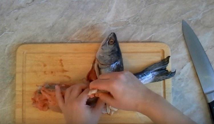 Having made an incision near the head, we remove the meat from the fish skin.