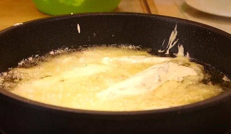 Après la farine, nous envoyons les morceaux de filet de morue dans la pâte et nous les transférons dans le plat à pommes de terre.