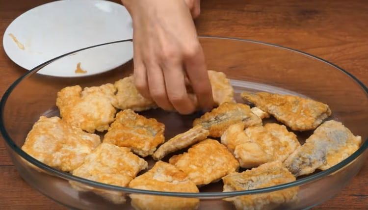 Ponga el pescado frito en una forma ligeramente engrasada con aceite vegetal.