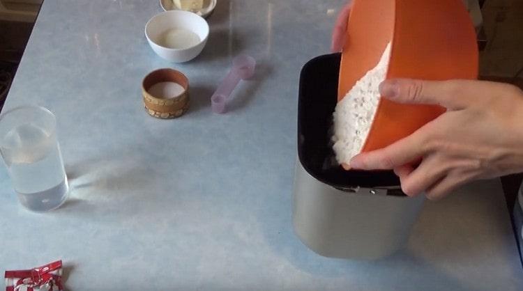 Versez la farine tamisée dans le seau de la machine à pain.