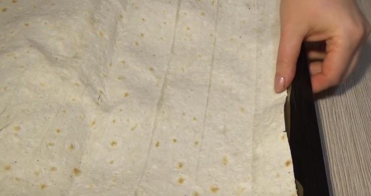 Sur une feuille de papier sulfurisé graissée à l’huile végétale sur une plaque à pâtisserie, nous posons une feuille de pain pita.