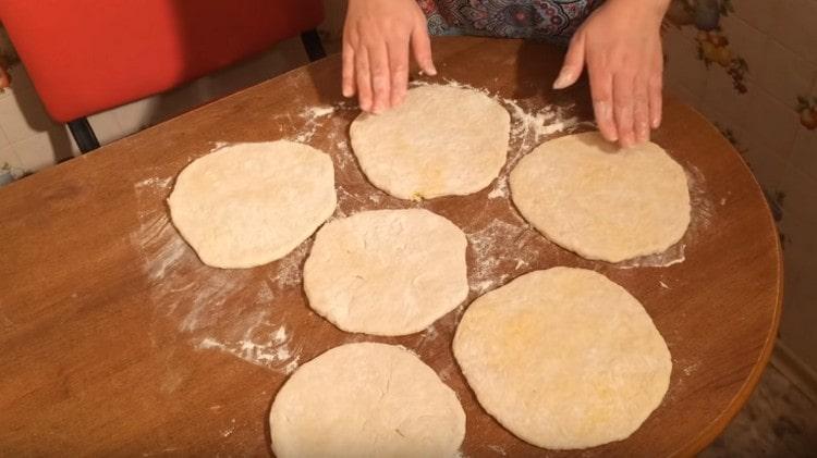 Nous mettons le produit obtenu avec un fond de couture et roulons un rouleau à pâtisserie en un gâteau.