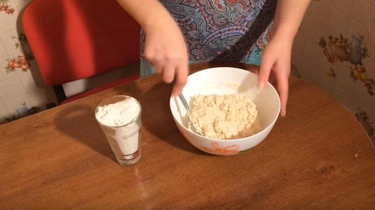 Pour kefir into flour and knead the dough.