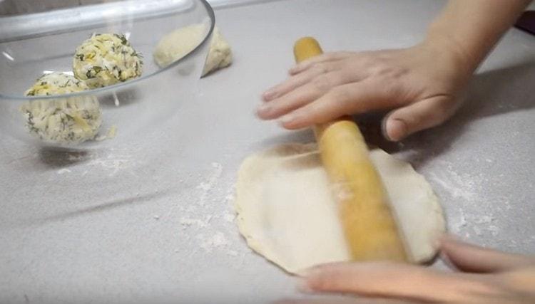 Dividing the dough into balls, each of them is rolled into a cake.
