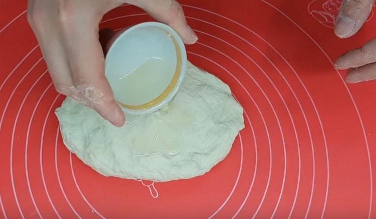 Add vegetable oil to the dough in two stages.