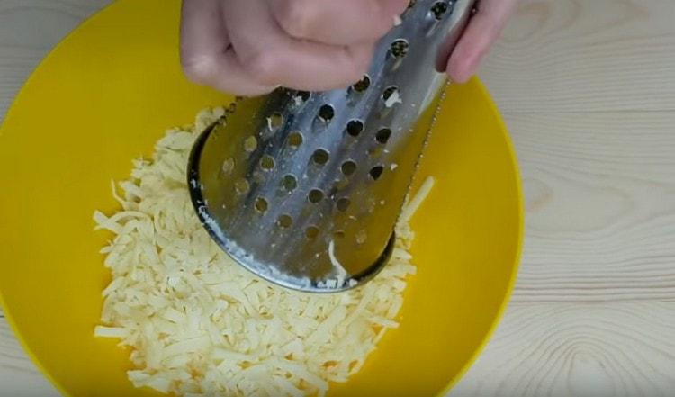 Rallar el queso suluguni en un rallador.