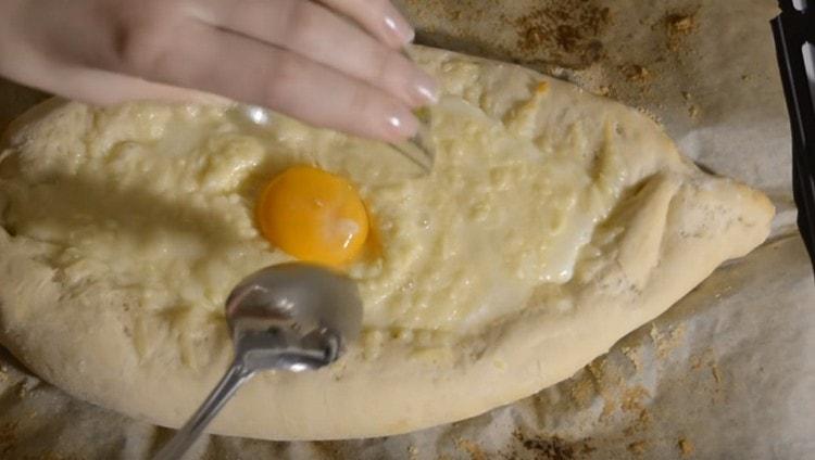 In the middle of the baking process of such a khachapuri, we beat out the egg in the center of the filling.