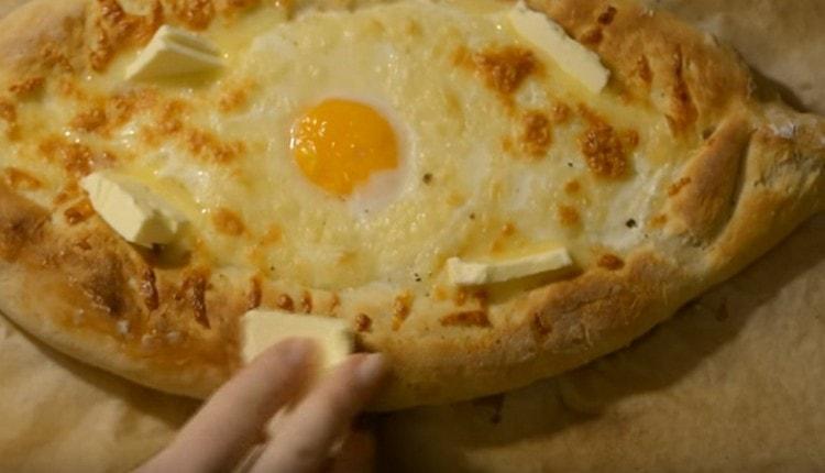 Lorsque nous servons des khachapuri avec des œufs, nous les lubrifions toujours avec un morceau d'huile.