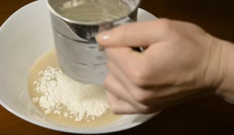 Sift flour into the mass.