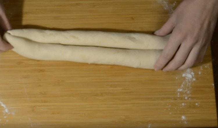 Dividing the dough in half, each piece is thinly rolled, then twist to the center from one and from the other edge with a roll.