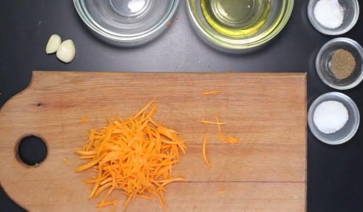 Sur une râpe pour les carottes coréennes, nous frottons les carottes.