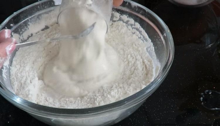 Pour dough into flour, add warm water.
