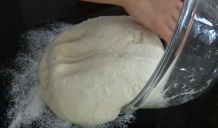 Nous déplaçons la pâte sur une table saupoudrée de farine.