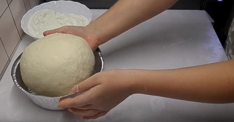 Having formed round bread, put it in a greased form with vegetable oil.