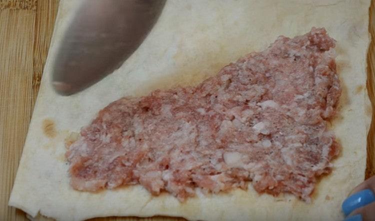 En la mitad del pan de pita, untamos la carne picada con un triángulo.