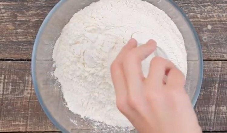 Prosijte brašno u zdjelu, pomiješajte ga sa solju.