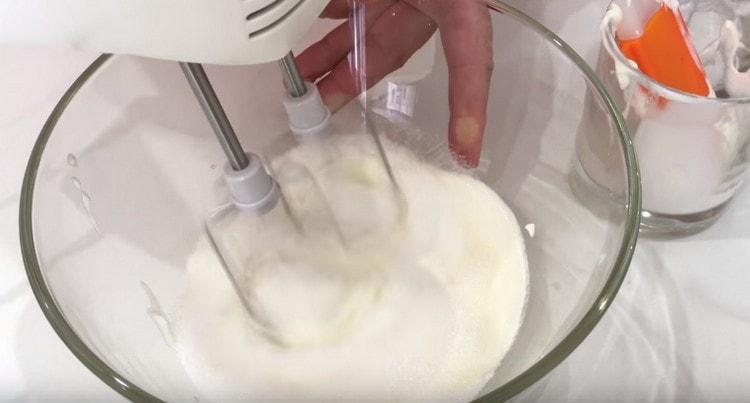 Beat sour cream with sugar with a mixer.