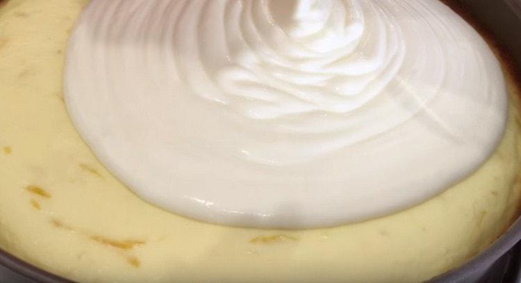 We cover with sour cream almost ready cheesecake.