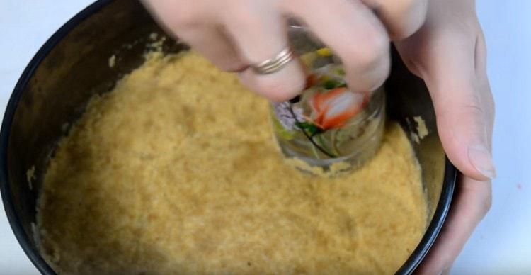 Navlažite masu, čineći temelj za kolač sira, a zatim poslajte obrazac s njim u hladnjak.